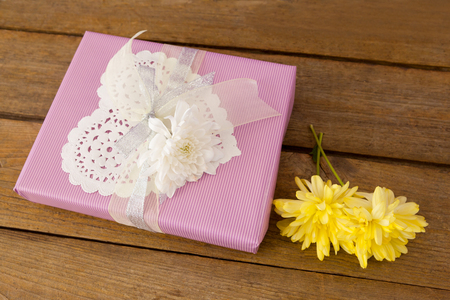 Close up of gift box with flowers on wooden tableの写真素材