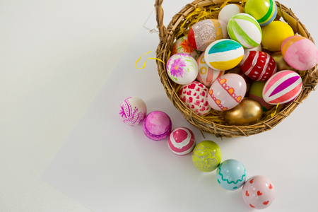 Close-up of basket with painted Easter eggs on white backgroundの写真素材