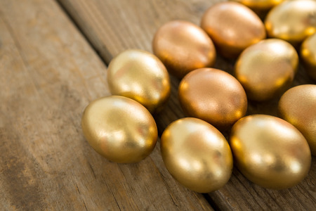 Close-up of golden Easter eggs on wooden surfaceの写真素材