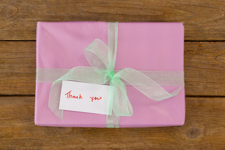 Thank you card with gift box on wooden tableの写真素材