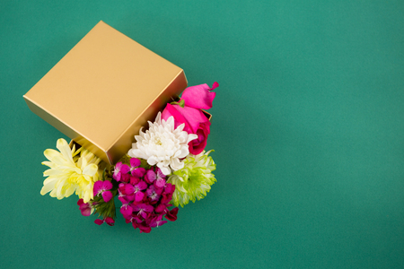 Close-up of gift box full of flower against green backgroundの写真素材