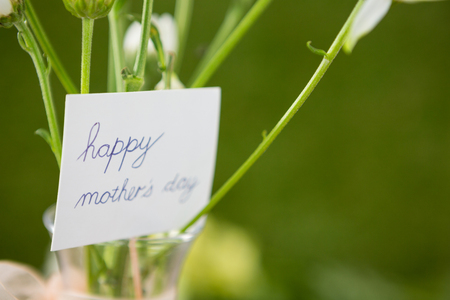 Close-up of happy mother day card on flower vaseの写真素材