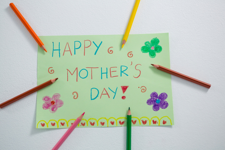 Color pencil arranged around mothers day greetings card on white backgroundの写真素材