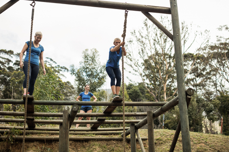 Fit woman holding the rope during obstacle course in boot camp
