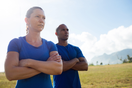 Female trainer and male trainer standing with arms crossed in bootcampの写真素材