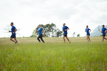 Low section of fit people running in boot campの写真素材