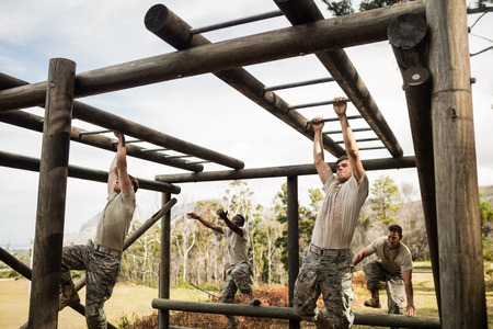 Soldiers climbing monkey bars in boot campの写真素材