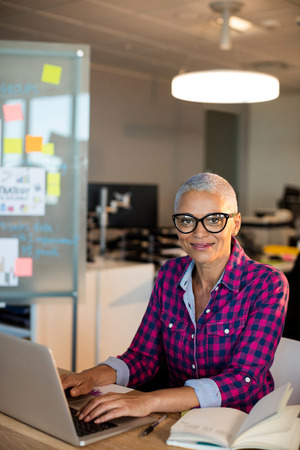 Portrait of creative businesswoman working on desk at officeの写真素材