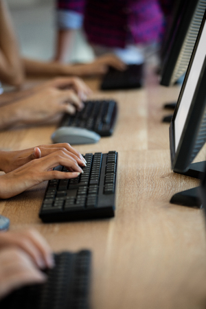 Customer service executives typing on their keyboards at officeの写真素材