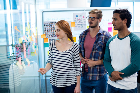 Creative business team disusing over the sticky notes in office