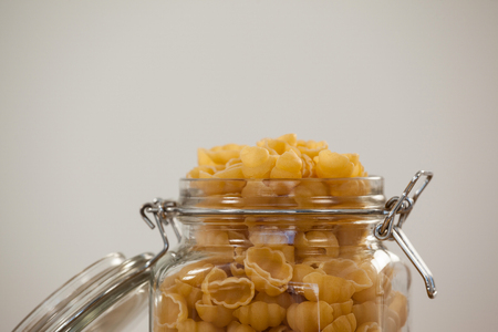 Conchiglie pasta in a jar on white backgroundの写真素材
