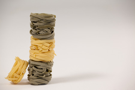 Roll of tagliatelle pasta on white backgroundの写真素材