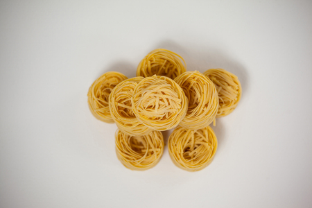 Tagliatelle pasta arranged in a row on white backgroundの写真素材