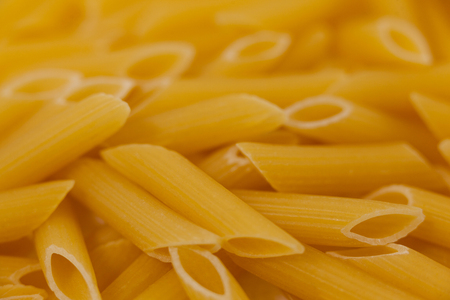 Close-up of pennette pasta on wooden surfaceの写真素材