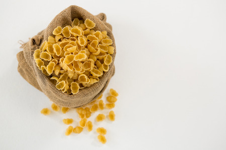 Sack full of pasta on white background