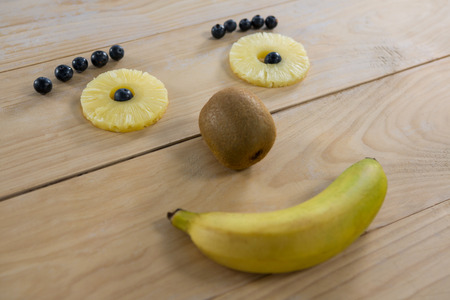 Various fruit arranged into smiley face on wooden tableの写真素材