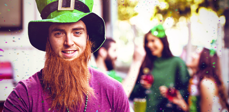 Flying colours against portrait of man celebrating st patricks day while holding beer glass 3dの写真素材
