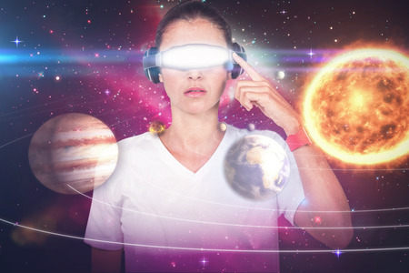 Beautiful woman with virtual video glasses against composite image of solar system against white...