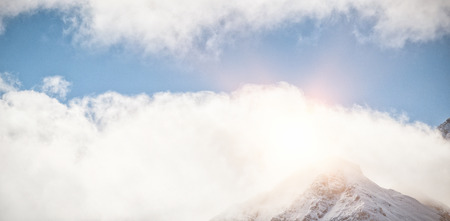 Low angle view of mountain top covered with cloudsの写真素材