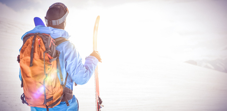 Rear view of skier looking at beautiful snow-covered mountainsの写真素材