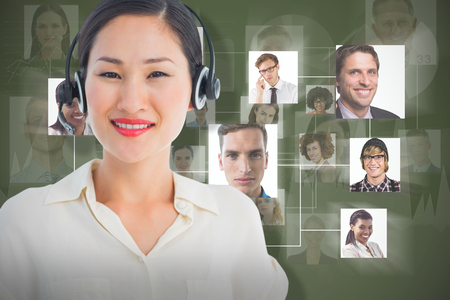 Beautiful smiling female executive with headset against green backgroundの写真素材