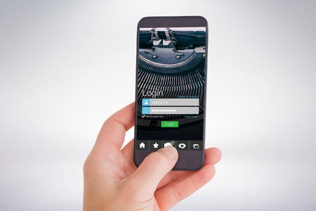 Female hand holding a smartphone against smartphone screenの写真素材