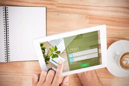 Close-up of login page against hands holding blank screen tabletの写真素材