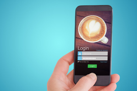 Female hand holding a smartphone against smartphone screen with coffee wallpaperの写真素材