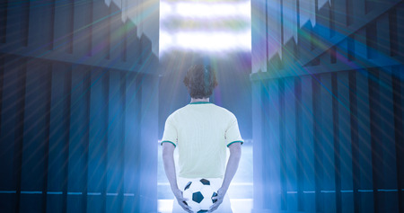 Rear view of football player holding ball at the back against football pitch with world cup flags 3dの写真素材
