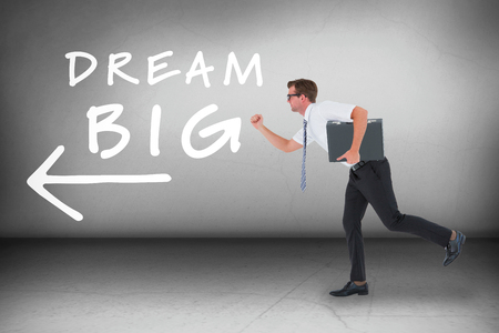 Running businessman against grey roomの写真素材