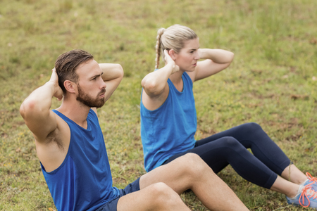Fit people performing crunches exercise in boot camp