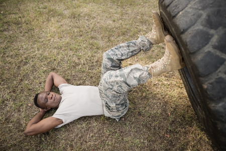 Determined military soldiers exercising with tyre in boot campの写真素材