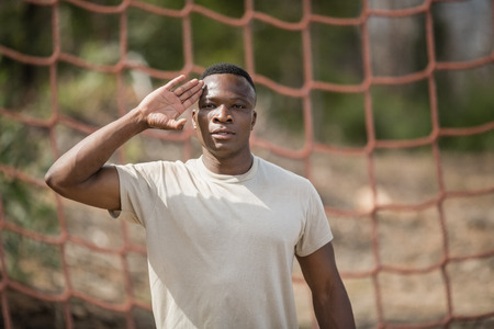 Military soldier giving salute during obstacle course in boot campの写真素材