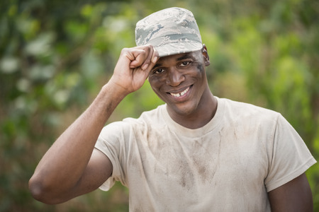 Portrait of happy military soldier holding his cap in boot camp