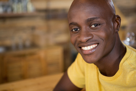 Close-up portrait of young man smiling in coffee houseの写真素材