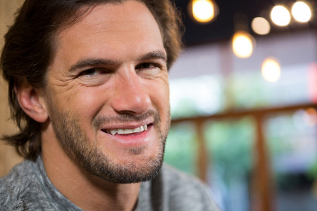 Close-up portrait of man smiling in coffee shopの写真素材