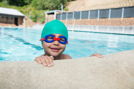 Portrait of smiling boy leaning on poolsideの写真素材