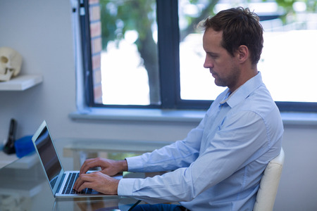 Dentist working on laptop in dental clinic