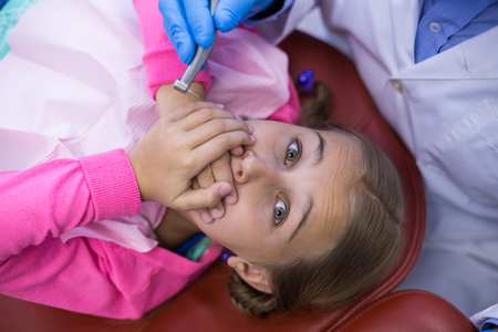 Young patient scared during a dental check-up at clinicの写真素材