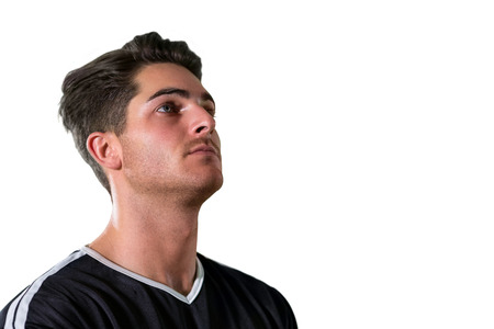 Thoughtful football player standing against white backgroundの写真素材