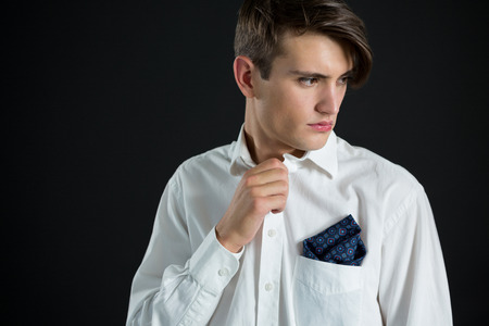 Thoughtful androgynous man posing against black backgroundの写真素材