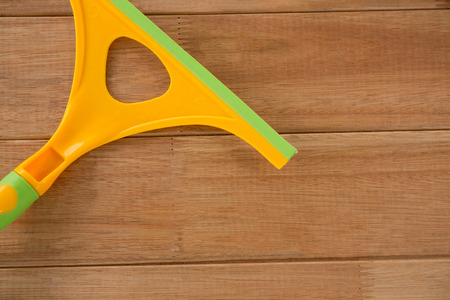 Cropped image of yellow wiper on wooden table
