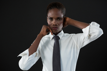 Portrait of androgynous man posing against grey backgroundの写真素材