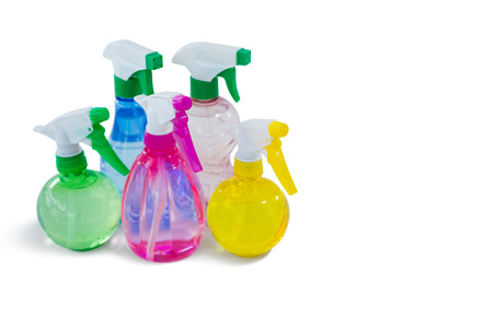 Close up of colorful spray bottles against white background
