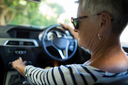 Rear view of serious senior woman driving carの写真素材