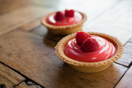 Close up of raspberry tart on wooden table at cafe shopの写真素材