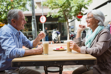 Senior couple interacting with each other in cafÃ©の写真素材