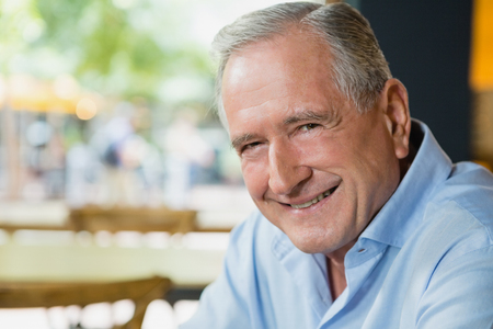 Portrait of happy senior man sitting in cafÃ©の写真素材