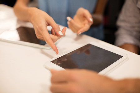 Close up of business people discussing on digital tablet at office