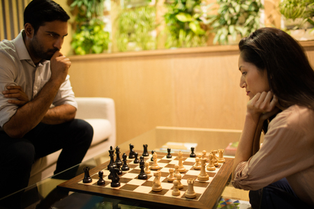 Serious business colleagues playing chess in officeの写真素材